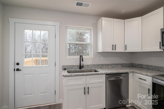 kitchen featuring stainless steel appliances, a sink, visible vents, and white cabinets