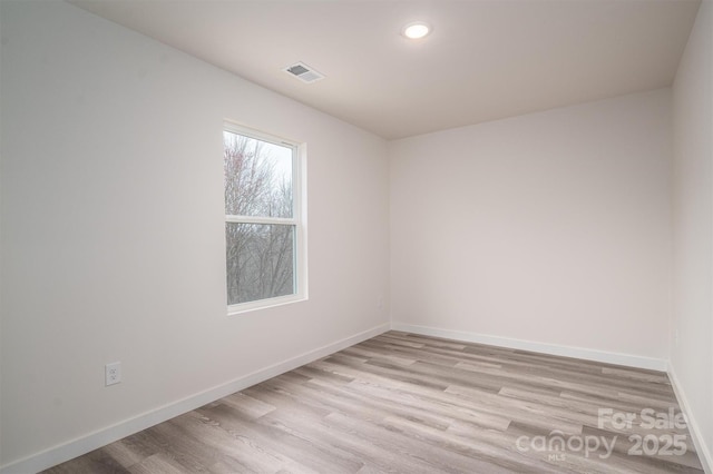 spare room featuring light wood-type flooring, visible vents, baseboards, and recessed lighting