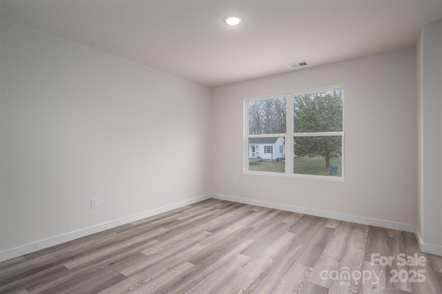 spare room featuring light wood-style floors, baseboards, visible vents, and recessed lighting