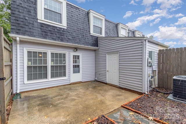 back of house featuring a patio, mansard roof, cooling unit, a shingled roof, and fence