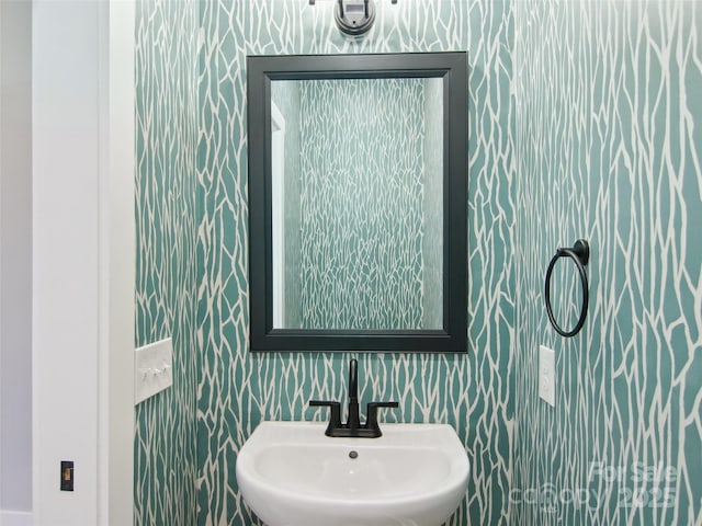 bathroom with a sink and wallpapered walls