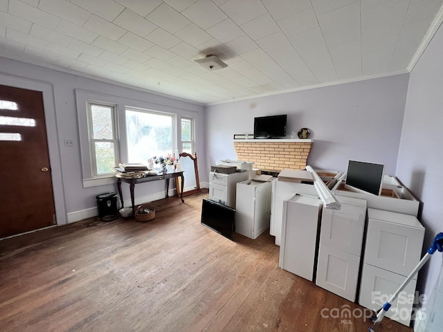 laundry room with baseboards, ornamental molding, and wood finished floors