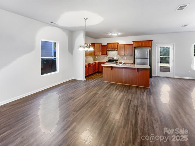 kitchen featuring stainless steel appliances, visible vents, light countertops, backsplash, and dark wood-style floors