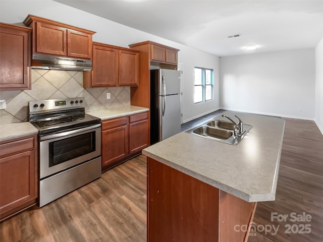 kitchen with visible vents, dark wood finished floors, appliances with stainless steel finishes, under cabinet range hood, and a sink