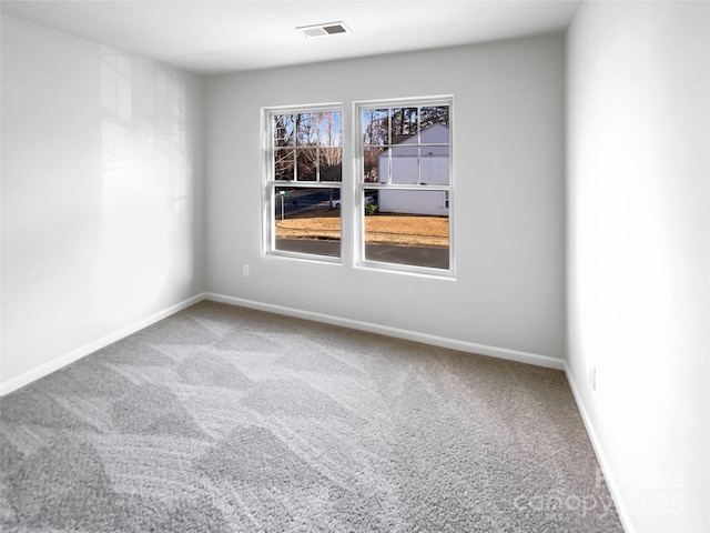 unfurnished room with carpet flooring, visible vents, and baseboards