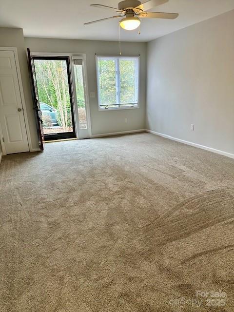 spare room with a ceiling fan, carpet flooring, and baseboards