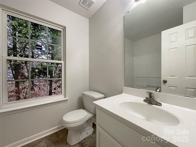 bathroom with a healthy amount of sunlight, visible vents, vanity, and toilet