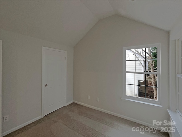 additional living space with carpet flooring, vaulted ceiling, and baseboards