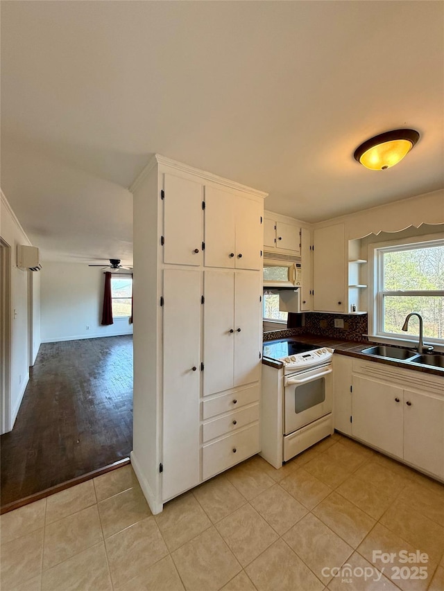 kitchen featuring a sink, an AC wall unit, range hood, dark countertops, and white electric range oven