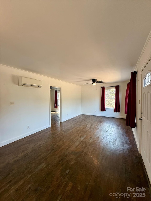 unfurnished living room featuring baseboards, a ceiling fan, dark wood-type flooring, and a wall mounted AC