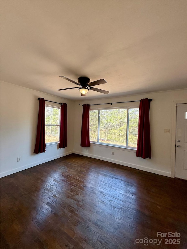 unfurnished room with dark wood-style floors, ceiling fan, and baseboards