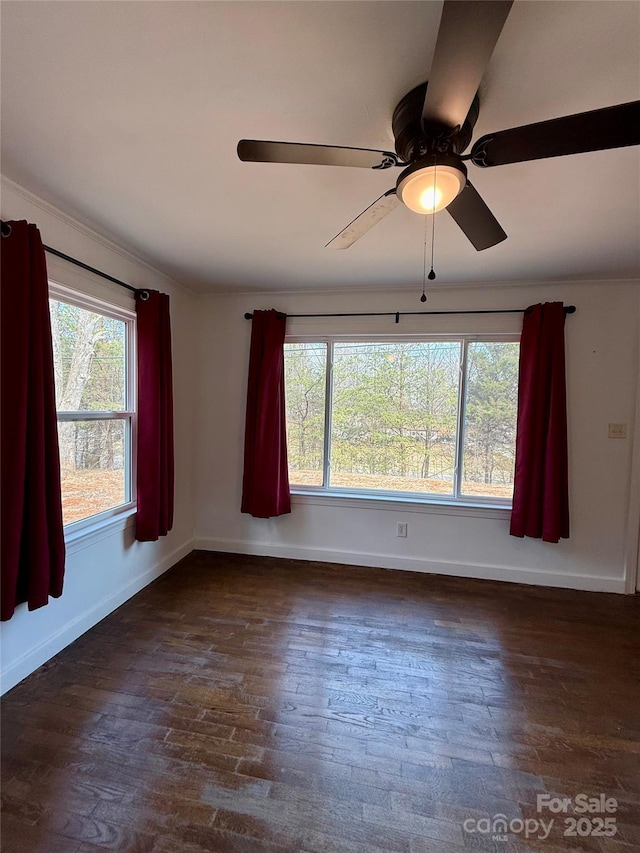 empty room featuring dark wood-style floors, ceiling fan, and baseboards