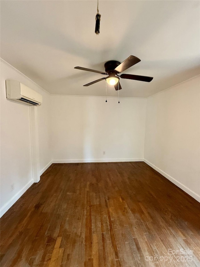 unfurnished room with a wall mounted air conditioner, wood finished floors, a ceiling fan, and baseboards