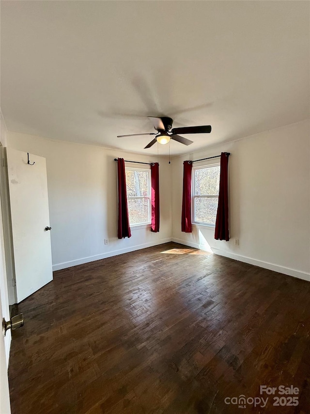 unfurnished room featuring ceiling fan, baseboards, and dark wood-type flooring