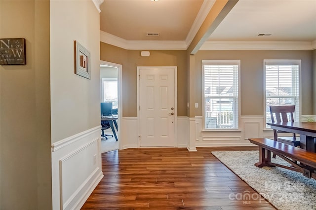 entryway with visible vents, dark wood-style floors, wainscoting, and ornamental molding