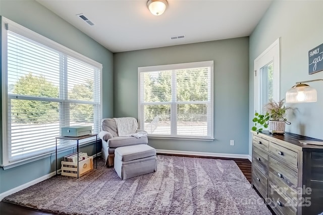 living area featuring dark wood finished floors, visible vents, and baseboards