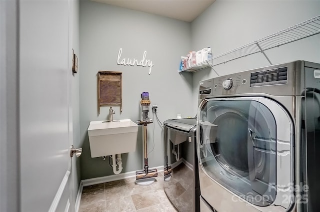 laundry room with baseboards, laundry area, and washer and clothes dryer