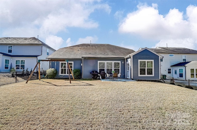 back of property with a yard, a playground, a fenced backyard, and a patio area