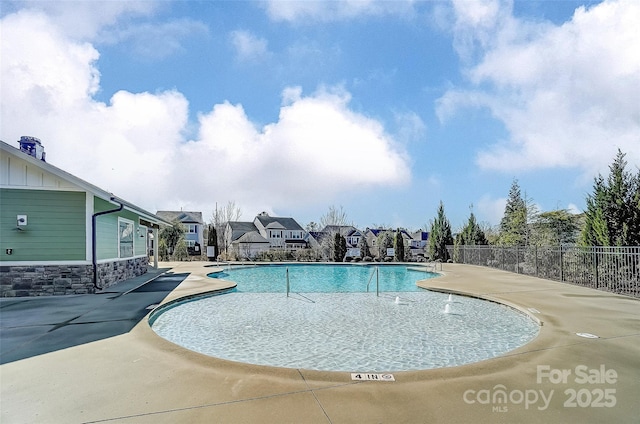 community pool featuring a residential view, a patio, and fence