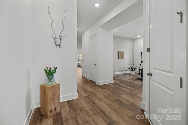 hallway featuring dark wood-type flooring, recessed lighting, and baseboards