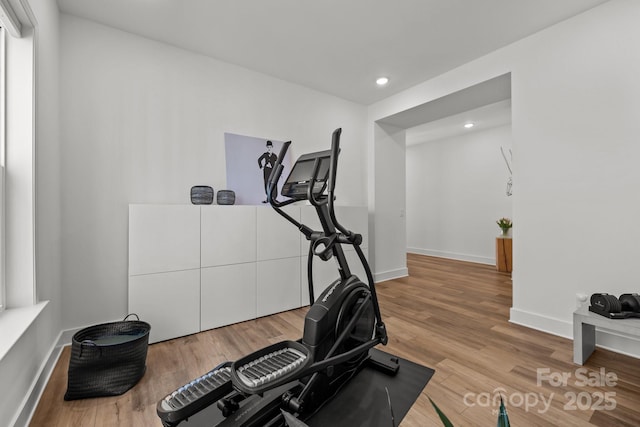 workout area featuring recessed lighting, baseboards, and wood finished floors