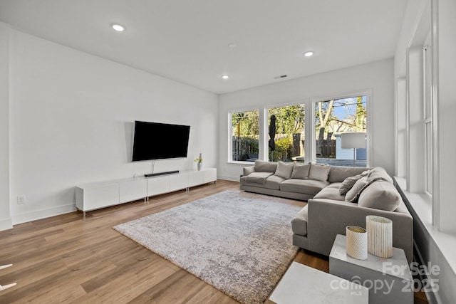 living room with baseboards, visible vents, wood finished floors, and recessed lighting