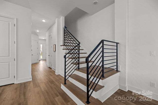 staircase with recessed lighting, baseboards, and wood finished floors