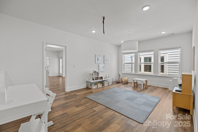 workout area with recessed lighting, baseboards, and wood finished floors