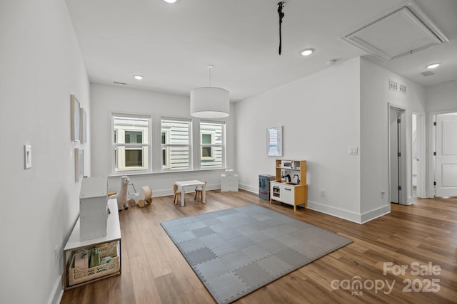 exercise room featuring recessed lighting, wood finished floors, visible vents, and baseboards