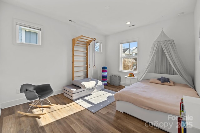 bedroom with recessed lighting, wood finished floors, visible vents, and baseboards