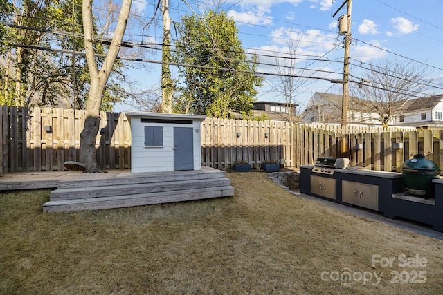 view of yard with a storage shed, a fenced backyard, a deck, and an outdoor structure