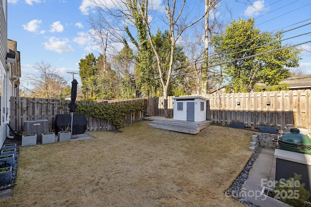 view of yard featuring a storage shed, a fenced backyard, cooling unit, and an outdoor structure