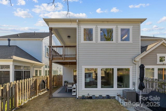 back of house with central AC, a patio area, a fenced backyard, and a balcony