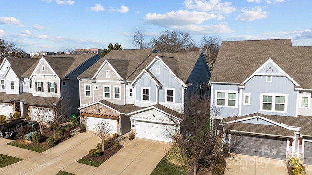 view of front of home featuring concrete driveway, board and batten siding, an attached garage, and a residential view