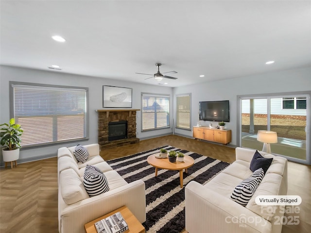 living room with a ceiling fan, recessed lighting, and a fireplace