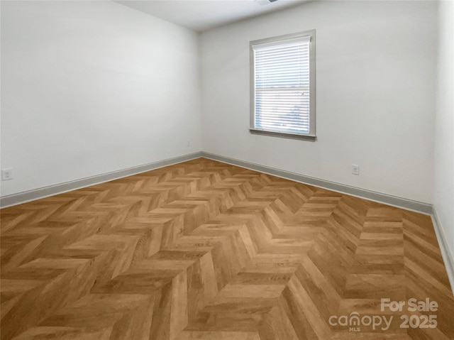 unfurnished room featuring baseboards