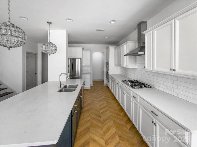 kitchen with stainless steel appliances, a sink, visible vents, a large island, and wall chimney exhaust hood