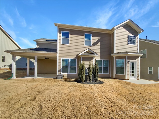 rear view of property featuring ceiling fan, a yard, and a patio area