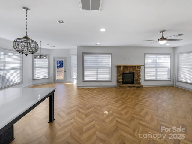 unfurnished living room featuring visible vents, a fireplace, a wealth of natural light, and recessed lighting