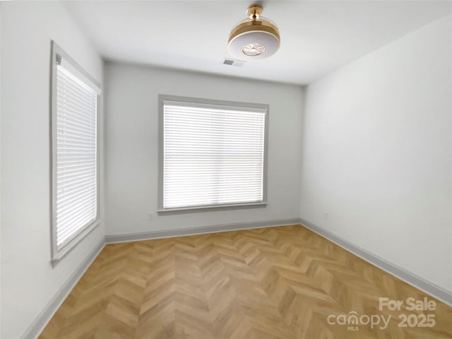 unfurnished room with visible vents and baseboards