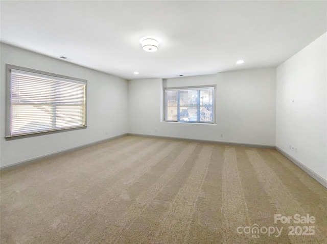 spare room featuring baseboards, recessed lighting, and light colored carpet