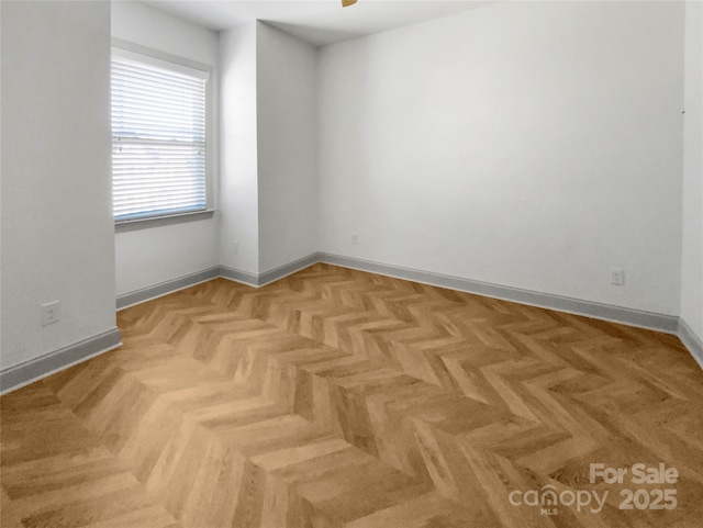 empty room featuring ceiling fan and baseboards