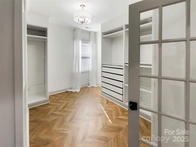 walk in closet featuring visible vents and a notable chandelier