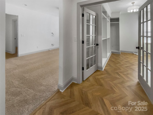 hall featuring baseboards and french doors