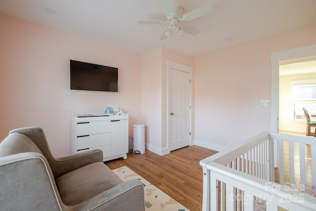 bedroom featuring light wood finished floors, baseboards, and a ceiling fan