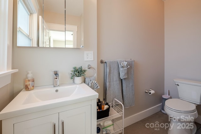 bathroom featuring toilet, vanity, and baseboards