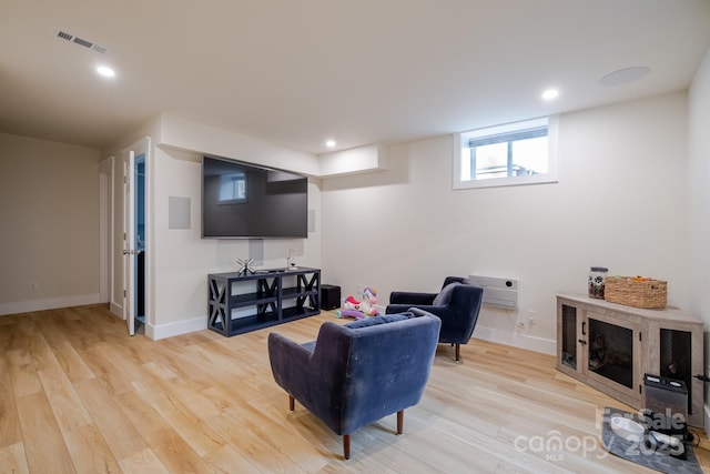 living room featuring light wood finished floors, baseboards, visible vents, and recessed lighting