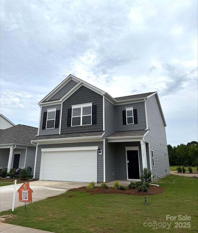 view of front of property featuring a garage, concrete driveway, and a front yard