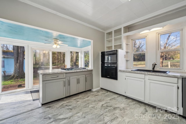 kitchen featuring a healthy amount of sunlight, stainless steel gas cooktop, ornamental molding, dobule oven black, and a sink