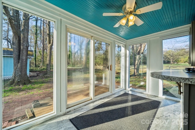 unfurnished sunroom featuring wooden ceiling and ceiling fan